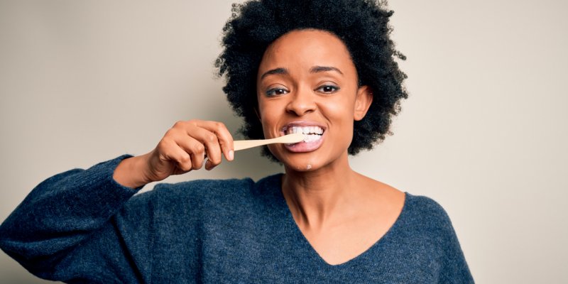 Mulher afro-americana escovando os dentes usando escova de dentes