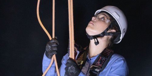 Trabalhador subindo escada em ambiente industrial
